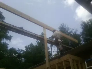 Carpenter setting a ridge beam over a new addition frame — Ice Dam Removal by Roofing Brothers in Sandisfield
