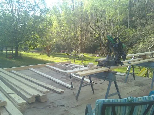 Miter saw and framing lumber on a deck under construction in Sandisfield