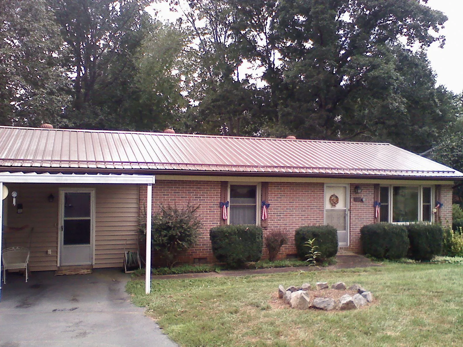 Bronze metal roof and carport on a brick ranch home — Roof Repair work by our crew in Sandisfield